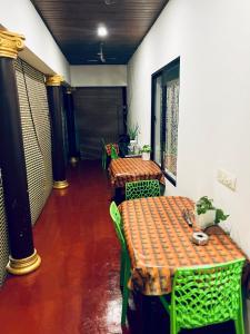 a room with two tables and chairs with a cat sitting on them at Marari Beach La Vista in Mararikulam