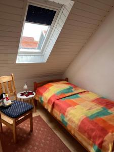 une chambre avec un lit et une chaise dans un grenier dans l'établissement Ferienhaus Barbara am Meer, à Horumersiel