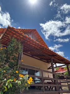 モンテ・ダス・ガメレイラスにあるChalé Vista Encanto dos Montesの空に太陽が輝く屋根のある家