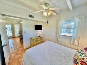 een slaapkamer met een bed en een plafondventilator bij Baked Beach Bungalow in St. George Island