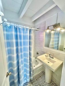 een badkamer met een wastafel en een douchegordijn bij Baked Beach Bungalow in St. George Island +12 foto's