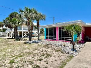 een huis met palmbomen ervoor bij Baked Beach Bungalow in St. George Island