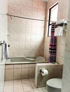 a bathroom with a tub and a toilet at Hotel Valladolid in Heredia +46 photos