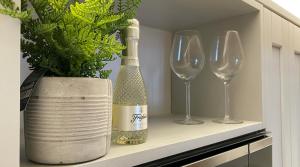 een fles champagne en twee wijnglazen op een plank bij Luxury Apartment Woodsmill View - on the river - with balcony - Recently refurbished in York +26 foto's