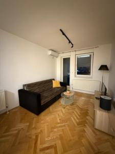 un soggiorno con letto e pavimento in legno di Xenia a Bijeljina