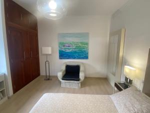 a bedroom with a bed and a chair and a painting at Serenity House in Tinajo