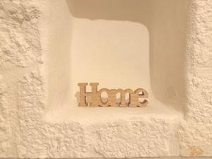 a home sign on a white wall with the word hate at Suite Salgemma in Polignano a Mare +3 photos