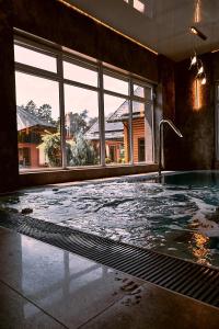 ein leerer Swimmingpool in einem Raum mit einem großen Fenster in der Unterkunft Anturazh Resort in Brody + 62 Fotos