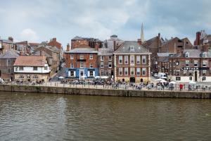 een stad aan een rivier met een groep gebouwen bij Luxury Apartment Woodsmill View - on the river - with balcony - Recently refurbished in York