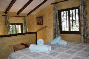 a bedroom with a bed with towels on it at Finca La Jara with private Pool in Cómpeta +25 photos