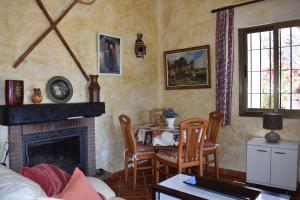 a living room with a table and a fireplace at Finca La Jara with private Pool in Cómpeta