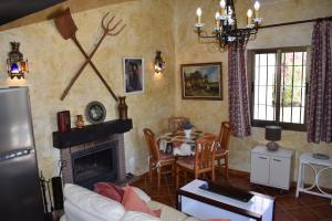 a living room with a fireplace and a table at Finca La Jara with private Pool in Cómpeta