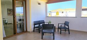 Una habitación con sillas y una mesa y una ventana. en Attico La Fenice, en Àrbatax