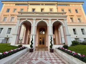 a large building with a door and flowers in front at Greif Hotel & Spa in Trieste