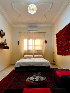 a bedroom with a bed and a window and a table at Dar Zina in Aourir +32 photos