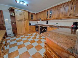 eine große Küche mit Holzschränken und einem Schachbrettboden in der Unterkunft Casa Rural Los Monteros in Espinosa de los Monteros + 17 Fotos