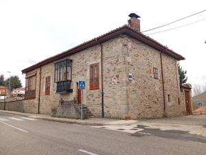 ein altes Steingebäude an der Straßenseite in der Unterkunft Casa Rural Los Monteros in Espinosa de los Monteros