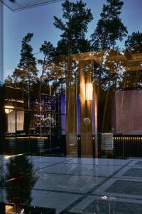 ein Gebäude mit einer Glasfassade mit Bäumen im Hintergrund in der Unterkunft Anturazh Resort in Brody