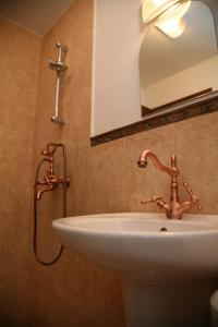 桑丹斯基的住宿－克洛希奧精品酒店，浴室水槽设有水龙头和镜子