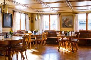 a restaurant with wooden tables and chairs and windows at Gasthaus Engel in Bezau