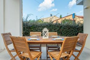 ein Holztisch mit vier Stühlen und einer Laterne in der Unterkunft Cormorani - Appartamento 7 in Golfo Aranci