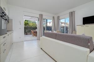 ein Wohnzimmer mit Couch und Küche in der Unterkunft Cormorani - Appartamento 7 in Golfo Aranci