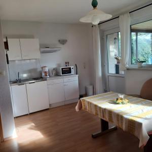 une cuisine avec une table recouverte d'une nappe dans l'établissement Ferienwohnung Heidi, à Bielatal 11 autres photos