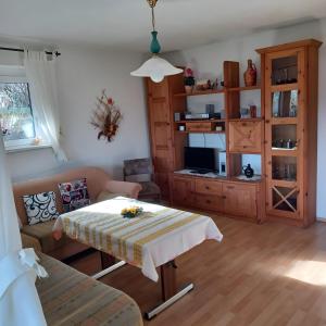 un salon avec une table et un canapé dans l'établissement Ferienwohnung Heidi, à Bielatal