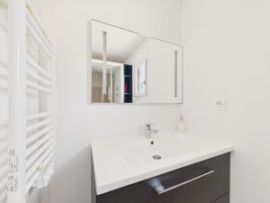 ein weißes Badezimmer mit Waschbecken und Spiegel in der Unterkunft Chalet pour 6, domaine avec piscine in Saint-Hilaire-de-Riez + 33 Fotos
