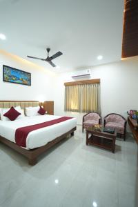 Un dormitorio con una cama grande y una mesa. en Hotel Nanda Mohan Residency, en Tirupati