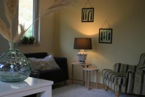 a living room with a couch and a vase on a table at Familiäres Pension Obere Juchhe in Gräfenthal