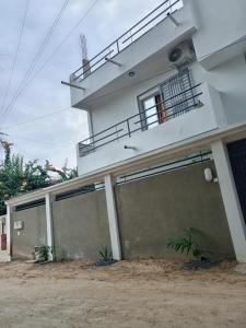 a house with two garage doors in front of it at Villa keur Baye fall in Sali Nianiaral