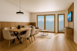 a living room with a table and chairs and a couch at PUREALPS Apartment - Opening December 2025 in Schwendberg