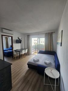 a bedroom with a blue bed and a table and chairs at Le Mirage Ibiza in San Antonio