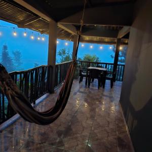 a hammock on the balcony of a house at Hacienda Mi Montañita in Los Altos de Cerro Azul