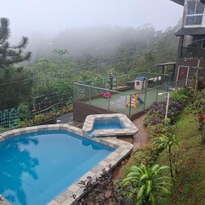 a swimming pool on the side of a house at Hacienda Mi Montañita in Los Altos de Cerro Azul