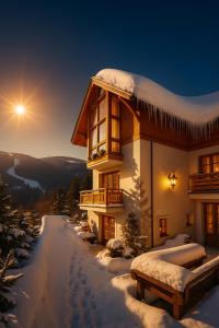 una casa en la nieve con el sol en el cielo en Pension Karolína, en Špindlerův Mlýn