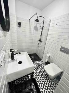 a white bathroom with a sink and a toilet at El Tesoro de Cadiz in Cádiz