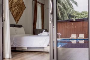 une chambre avec un lit et une porte coulissante en verre dans l'établissement Ao Nang Boutique Apartment & Pool, à Ban Chong Phli