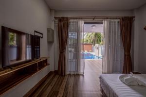 une chambre avec un lit et une porte coulissante en verre donnant sur une piscine dans l'établissement Ao Nang Boutique Apartment & Pool, à Ban Chong Phli