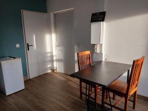 ein Esszimmer mit einem Tisch und Stühlen sowie einem Kühlschrank in der Unterkunft Studio des huis Kitchenette-Salle de bain-Terrasse 
