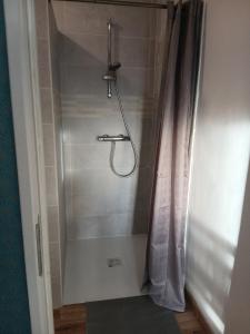 eine Dusche mit Duschvorhang im Bad in der Unterkunft Studio des huis Kitchenette-Salle de bain-Terrasse 