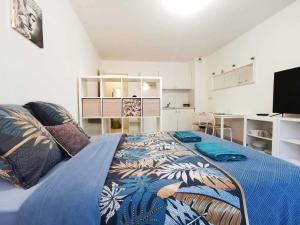 a bedroom with a large bed with a blue blanket at Studio Zen I Hypercentre I Parking privé I Patio I WIFI in Salon-de-Provence