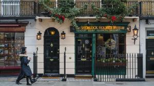 uma mulher caminhando em frente a um prédio em Bikki Apartments - 2 Bedroom self contained em Harrow