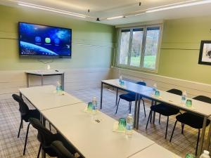 een conferentieruimte met tafels en stoelen en een flatscreen-tv bij Logis La Ferme Du Vert in Wierre-Effroy