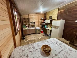 eine Küche mit einem Tisch und einem Kühlschrank in der Unterkunft Sítio reservado com piscina in Viamão + 15 Fotos