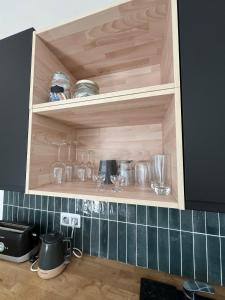 una cocina con armarios de madera con objetos de cristal encima en Escape Room Codex Verha - Logement insolite Nancy, en Nancy 3 fotos más