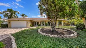 a house with a tree in the front yard at Gulf Birdie - 5551 in Siesta Key