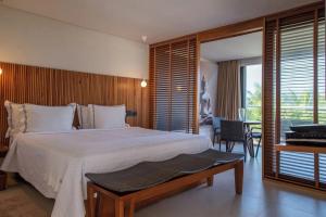 a bedroom with a large bed and a balcony at Hotel Spa Nau Royal in Camburi +67 photos