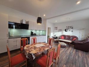 a kitchen and a living room with a table and chairs at Apartment am Saaleradwanderweg in Merseburg +10 photos